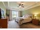 This bedroom features a tray ceiling, ceiling fan, a neutral color palette, and a view of the backyard at 603 Goal Kick Dr, Fuquay Varina, NC 27526
