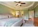 This bedroom has neutral walls, carpet, and a tray ceiling with views of the bathroom and laundry room at 603 Goal Kick Dr, Fuquay Varina, NC 27526