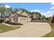 Spacious two-car garage with a long driveway, surrounded by lush greenery and well-kept landscaping at 603 Goal Kick Dr, Fuquay Varina, NC 27526