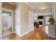 Hallway with hardwood floors leading to the bathroom and living room with a fireplace, offering seamless flow at 603 Goal Kick Dr, Fuquay Varina, NC 27526
