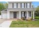 Home with inviting front porch, black shutters, beautiful garden, and well-maintained lawn at 622 Twain Town Dr, Knightdale, NC 27545