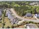 An aerial view displays a neighborhood surrounded by dense trees, featuring well-manicured lawns and established landscaping at 7825 Green Hope School Rd, Cary, NC 27519
