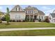 Charming two-story home featuring stone accents, a covered porch, and beautifully landscaped front yard at 7825 Green Hope School Rd, Cary, NC 27519