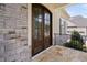 Elegant front door with glass panels, stone accents, and a stylish porch at 7825 Green Hope School Rd, Cary, NC 27519