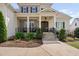 Elegant home facade with stone accents, a covered porch, and meticulously landscaped garden at 7825 Green Hope School Rd, Cary, NC 27519