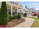 Home's covered porch features stone steps, manicured landscaping, and an inviting entrance at 7825 Green Hope School Rd, Cary, NC 27519