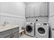 This laundry room features gray cabinets, white walls, and Samsung washing and dryer machines at 7825 Green Hope School Rd, Cary, NC 27519