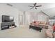Open living room with comfortable sofa, ceiling fan, entertainment center, and a flat screen television at 7825 Green Hope School Rd, Cary, NC 27519