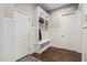 Mudroom features a built-in bench, storage hooks, and cabinets, adjacent to hardwood floors at 7825 Green Hope School Rd, Cary, NC 27519
