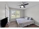 Bright and airy bedroom with ceiling fan, large window, and neutral decor at 82 Sommerset Dr, Clayton, NC 27520
