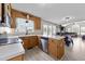 Eat-in kitchen featuring wood cabinets, stainless steel appliances, and breakfast bar with view into Gathering room at 82 Sommerset Dr, Clayton, NC 27520
