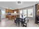 Eat-in kitchen featuring wood cabinets, modern appliances, breakfast bar, and adjacent dining area with large windows at 82 Sommerset Dr, Clayton, NC 27520