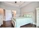 Well-lit bedroom with trey ceiling, hardwood floors, and ensuite bathroom access for seamless living at 85 Bramble Ln, Clayton, NC 27527