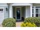 Inviting front entrance with a stylish blue door, complemented by lush green shrubbery at 85 Bramble Ln, Clayton, NC 27527
