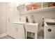 Bright laundry room with white cabinetry, utility sink, and modern washing machine for convenient chores at 85 Bramble Ln, Clayton, NC 27527