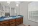 Bathroom boasts double sinks, wood cabinets, and a large mirror with vanity lighting at 922 Royal Oaks Dr, Durham, NC 27712