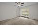 A bright bedroom with carpet, a window with blinds, and an open door to another room at 922 Royal Oaks Dr, Durham, NC 27712