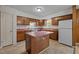 Functional kitchen with ample counter space, wooden cabinets, and a center island for meal preparation at 922 Royal Oaks Dr, Durham, NC 27712