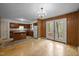 Open kitchen and dining area featuring wood paneling and access to the backyard through double doors at 922 Royal Oaks Dr, Durham, NC 27712