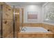 Bright bathroom featuring tiled shower with glass door and soaking tub at 104 Glenview Pl, Chapel Hill, NC 27514