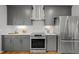 Well-lit kitchen featuring stainless steel appliances, white countertops, and gray cabinetry at 104 Glenview Pl, Chapel Hill, NC 27514