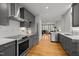 Modern kitchen with stainless steel appliances and gray cabinets open to the living area at 104 Glenview Pl, Chapel Hill, NC 27514