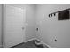 Laundry room with a white door, dark gray tile floor, and utility hook rack at 104 Glenview Pl, Chapel Hill, NC 27514
