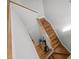 Wooden staircase descending to a hardwood landing with a small table at 104 Glenview Pl, Chapel Hill, NC 27514