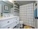 Well-lit bathroom featuring a vanity with white cabinets and a shower with a patterned curtain at 105 Guldahl Ct, Morrisville, NC 27560