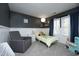 Cozy bedroom with wainscoting, gray walls, and a comfortable armchair near a twin bed at 105 Guldahl Ct, Morrisville, NC 27560