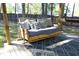 Relaxing covered deck area with a cozy, cushioned porch swing, and stylish outdoor rug for comfort at 105 Guldahl Ct, Morrisville, NC 27560