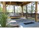 Inviting covered deck area with a cozy swing bed and outdoor firepit, perfect for relaxing and entertaining at 105 Guldahl Ct, Morrisville, NC 27560