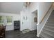 Bright entryway with high ceilings, modern light fixture, a gray cabinet, and staircase leading to the upper level at 105 Guldahl Ct, Morrisville, NC 27560