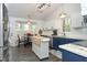 Bright kitchen featuring white cabinetry, blue cabinets, granite countertops, and a charming breakfast nook by the window at 105 Guldahl Ct, Morrisville, NC 27560