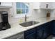 Close-up of kitchen sink featuring granite countertops, white subway tile backsplash, and sleek, stainless steel appliances at 105 Guldahl Ct, Morrisville, NC 27560