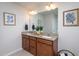 Bathroom with a double vanity, granite countertops, and framed mirrors above both sinks at 108 Pronghorn Deer Ct, Garner, NC 27529