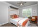 Cozy bedroom featuring a murphy bed, a ceiling fan, a window, and stylish decor creating an inviting atmosphere at 108 Pronghorn Deer Ct, Garner, NC 27529