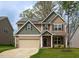 Charming two-story home with a two-car garage, stone accents, and solar panels on the roof at 108 Pronghorn Deer Ct, Garner, NC 27529