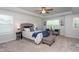 Relaxing main bedroom with a tray ceiling, ceiling fan, sitting area, and a plush bed bathed in natural light at 108 Pronghorn Deer Ct, Garner, NC 27529