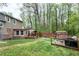Spacious backyard with brick accents, a wooden deck, mature trees, and a storage shed at 1105 Terrace Ct, Raleigh, NC 27615