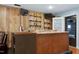 Rustic bar area with a counter, shelves, TVs, and wood-paneled walls at 1105 Terrace Ct, Raleigh, NC 27615
