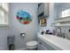 Bright bathroom featuring a stylish gray vanity, modern fixtures, and colorful wall art at 1105 Terrace Ct, Raleigh, NC 27615