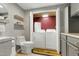 Neutral bathroom with wooden shelves, a toilet, cabinets, and laundry machines at 1105 Terrace Ct, Raleigh, NC 27615