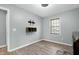 Minimalist bedroom with wood-look floors, a mounted TV, and floating shelves for storage at 1105 Terrace Ct, Raleigh, NC 27615
