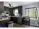 Updated kitchen with dark cabinets, granite countertops, stainless steel appliances, and natural light at 1105 Terrace Ct, Raleigh, NC 27615