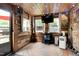 Enclosed patio featuring wood paneling, mounted TV, fans, seating, rug, and string lights at 1105 Terrace Ct, Raleigh, NC 27615