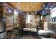 Enclosed patio featuring wood paneling, mini fridge, stools, seating area, and string lights at 1105 Terrace Ct, Raleigh, NC 27615
