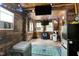 Enclosed patio with wood paneling, mounted TVs, fans, seating, and a mini fridge at 1105 Terrace Ct, Raleigh, NC 27615