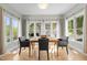 Bright dining room with large windows, a modern table, and comfortable seating for four at 119 Weaver Mine Trl, Chapel Hill, NC 27517