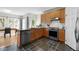 Bright kitchen with wood cabinets, stainless steel dishwasher, and a view to an open dining area at 119 Weaver Mine Trl, Chapel Hill, NC 27517